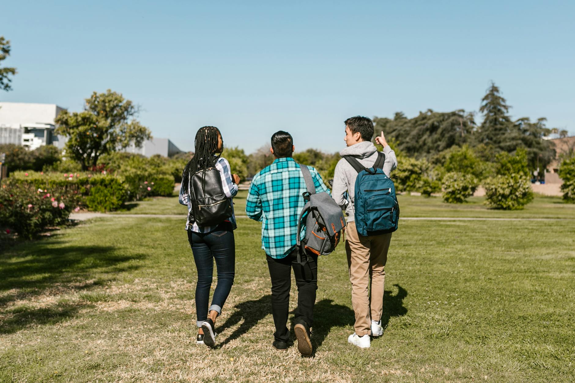 three college students walking on the ground